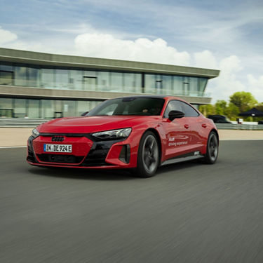 Roter Audi RS e-tron GT fährt am Audi Driving Experience Center vorbei