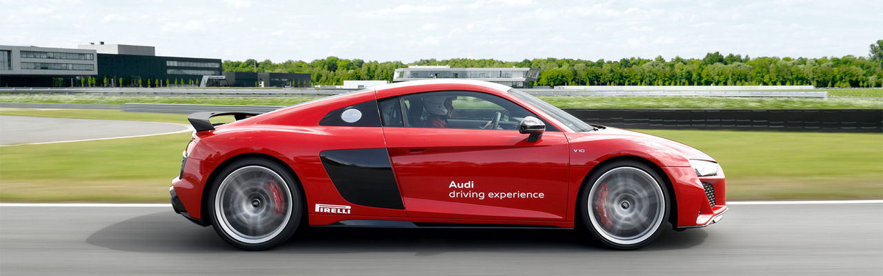 Roter Audi R8 Coupé fährt auf Rennstrecke (Seitenansicht des Modells)