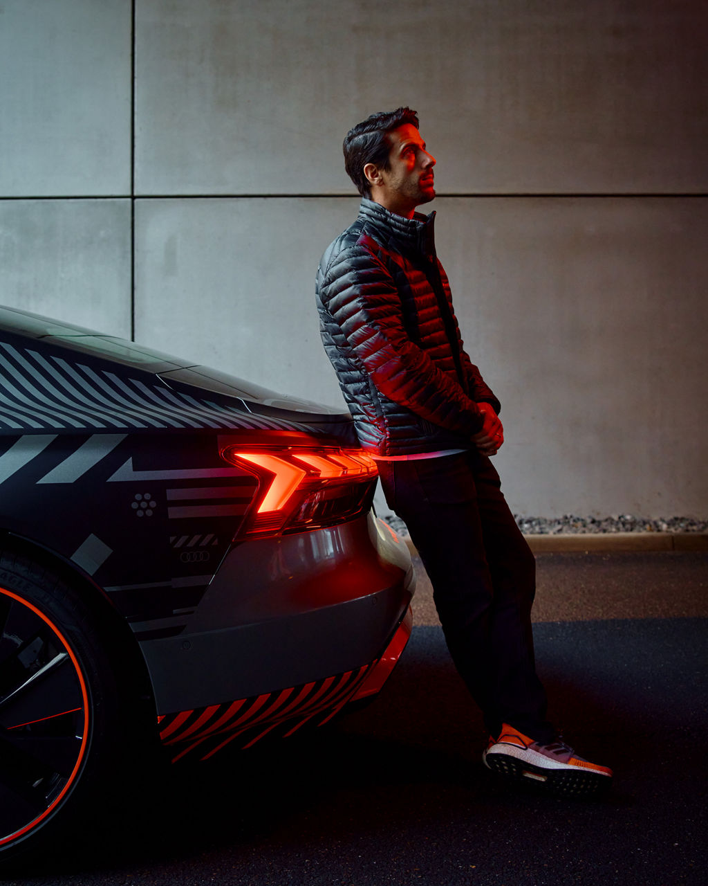 Lucas di Grassi s'appuie contre une Audi e-tron GT quattro.
