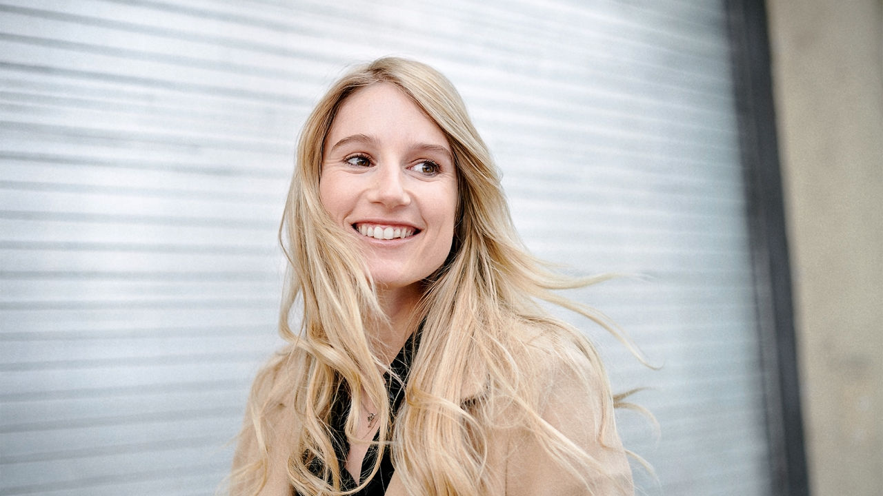 Portrait d’Anna Gasser devant un fond flou, en extérieur