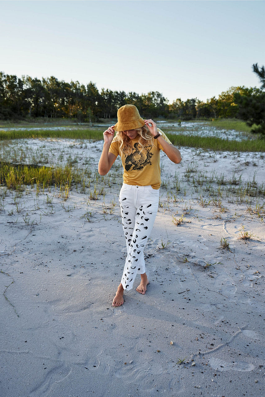 Plan en pied de Steph Gilmore en plein air, avec un chapeau de soleil.
