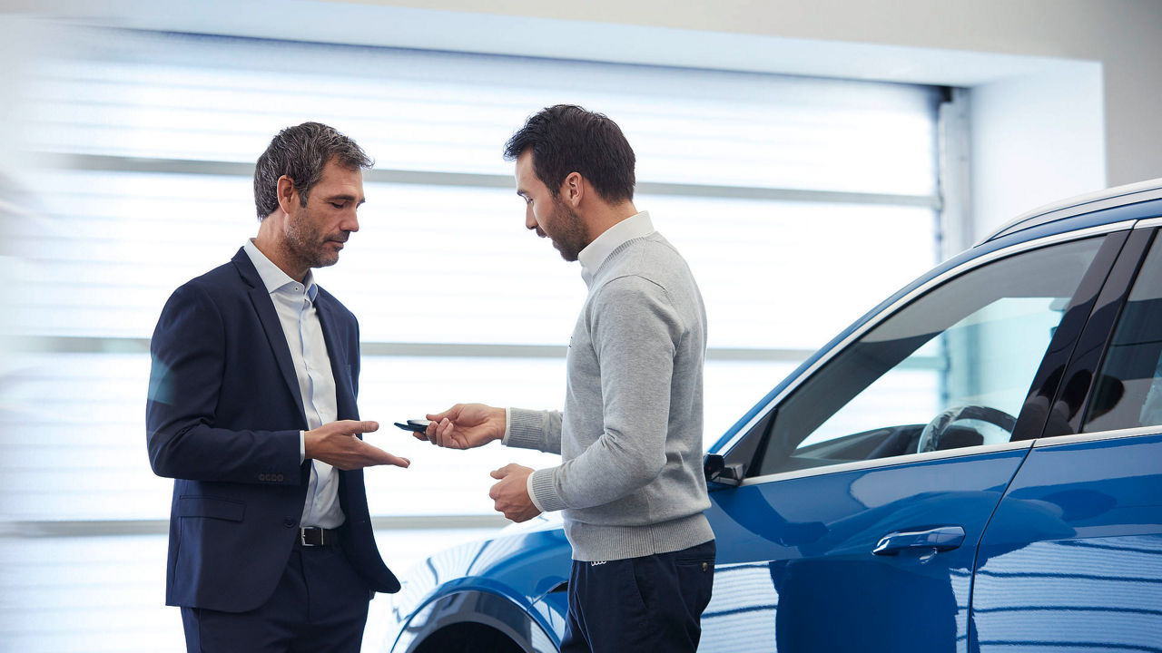  Dimostrazione del servizio AudiforAudi, un uomo consegna le chiavi di un veicolo Audi ad un cliente.