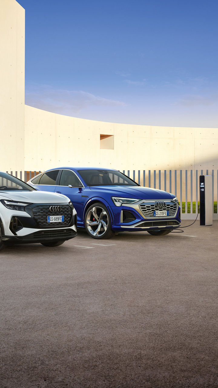 Vista di un'Audi Q4 e-tron e Q8 e-tron della Gamma Business in fase di ricarica.