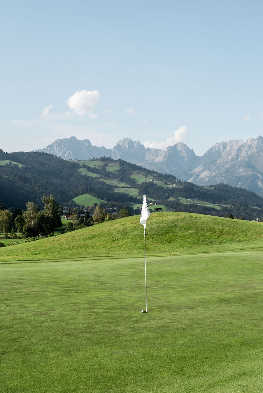 Vaste green vallonné, en arrière-plan les montagnes : le parcours de golf de Kitzbühel bénéficie d'un cadre magnifique.