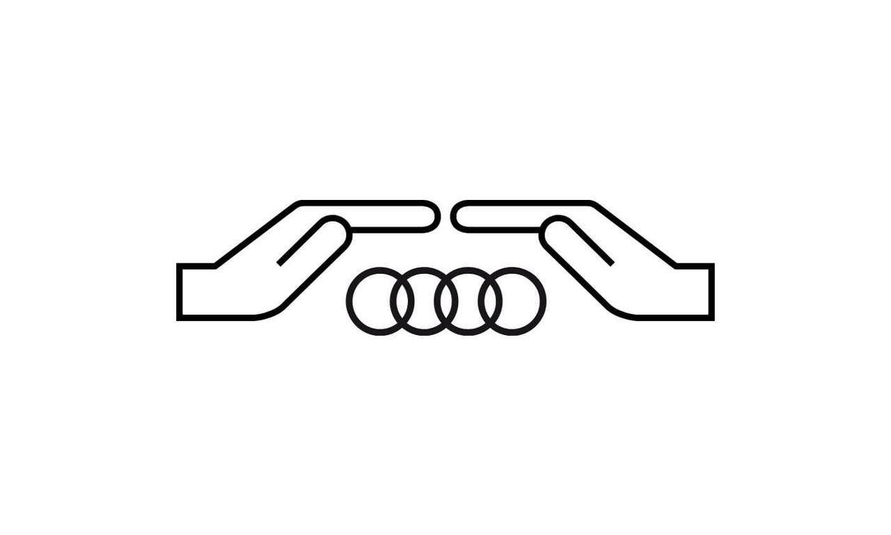 Zwei Hände über dem Audi Logo