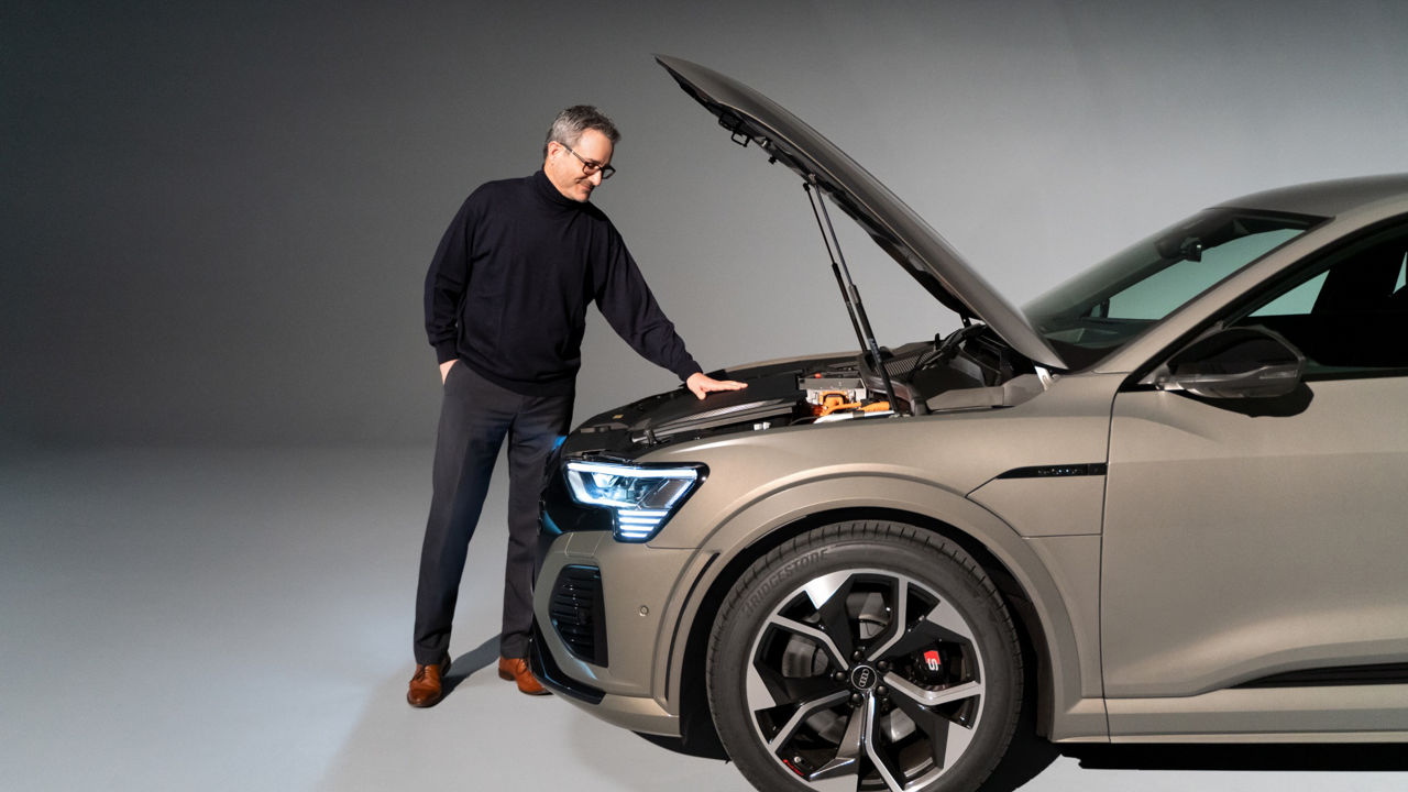 Joachim Doerr taking a look into the open bonnet of the Audi SQ8 e-tron.