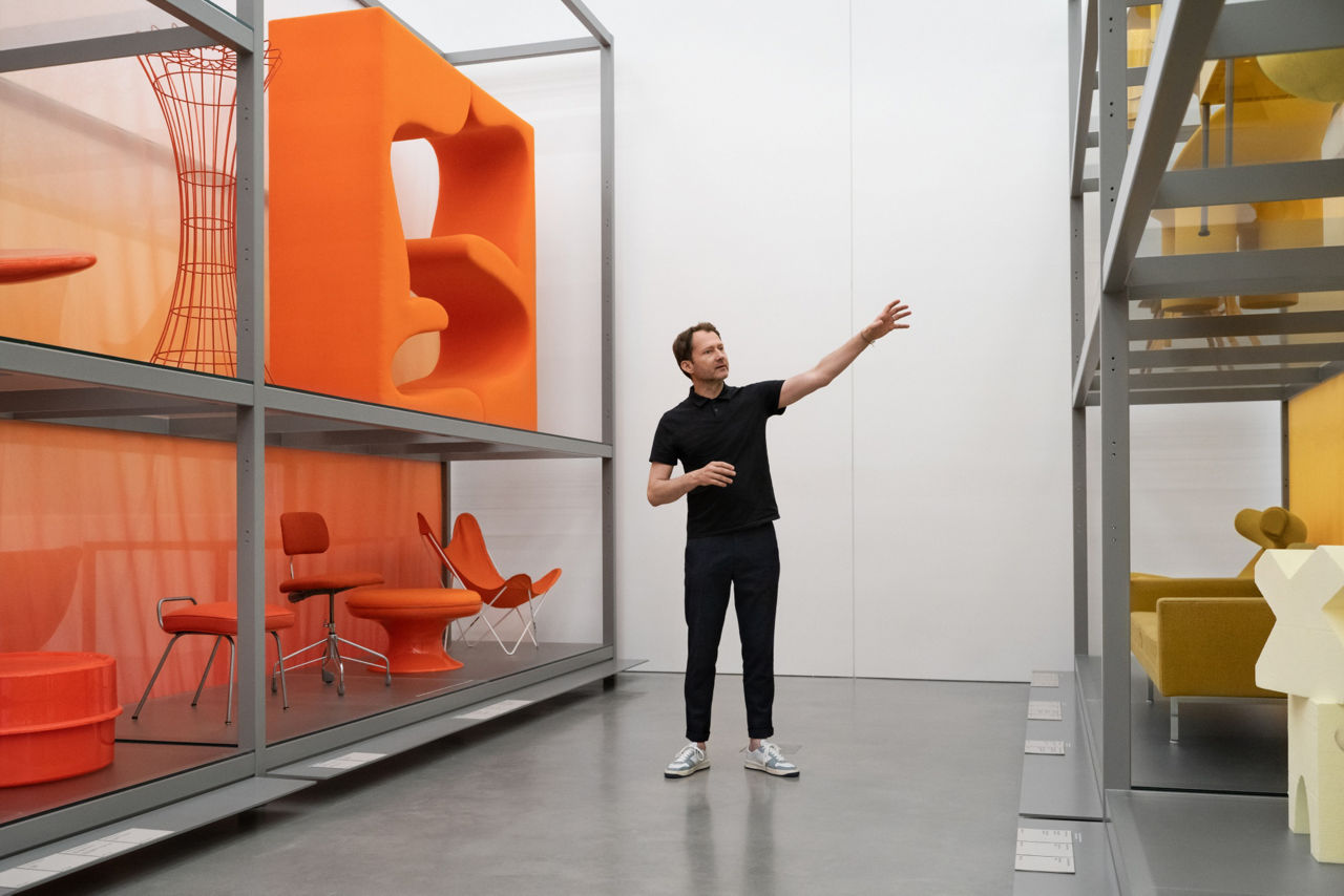 Dr. Mateo Kries steht vor den Regalen im Schaudepot.