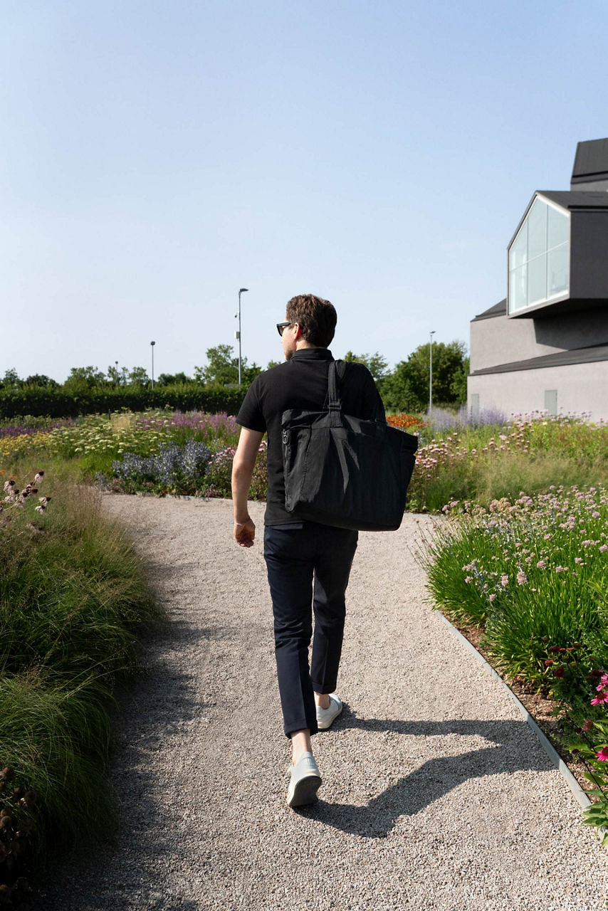 Dr. Mateo Kries läuft zwischen Blumenwiesen auf dem Vitra Campus.