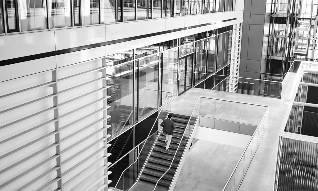 A spacious staircase in which Giorgio Delucchi is climbing up the stairs.