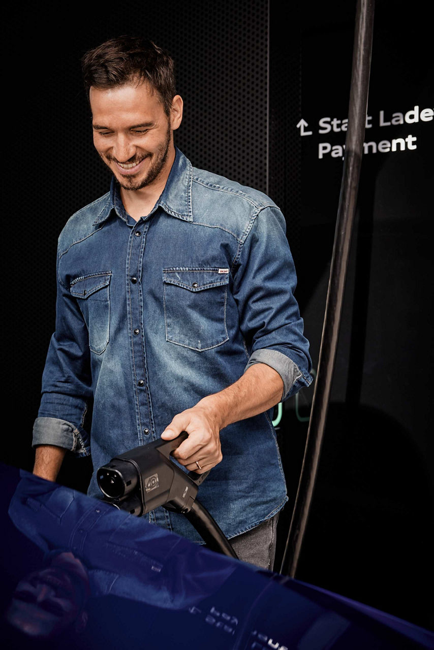 Felix Neureuther with a charging plug in his hand.