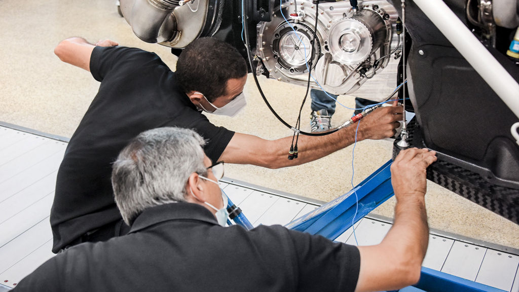 Working on the heart of the Audi RS Q e-tron: Two Audi Sport employees check the vehicle’s drive system, which will take it to the starting line of the Dakar Rally.