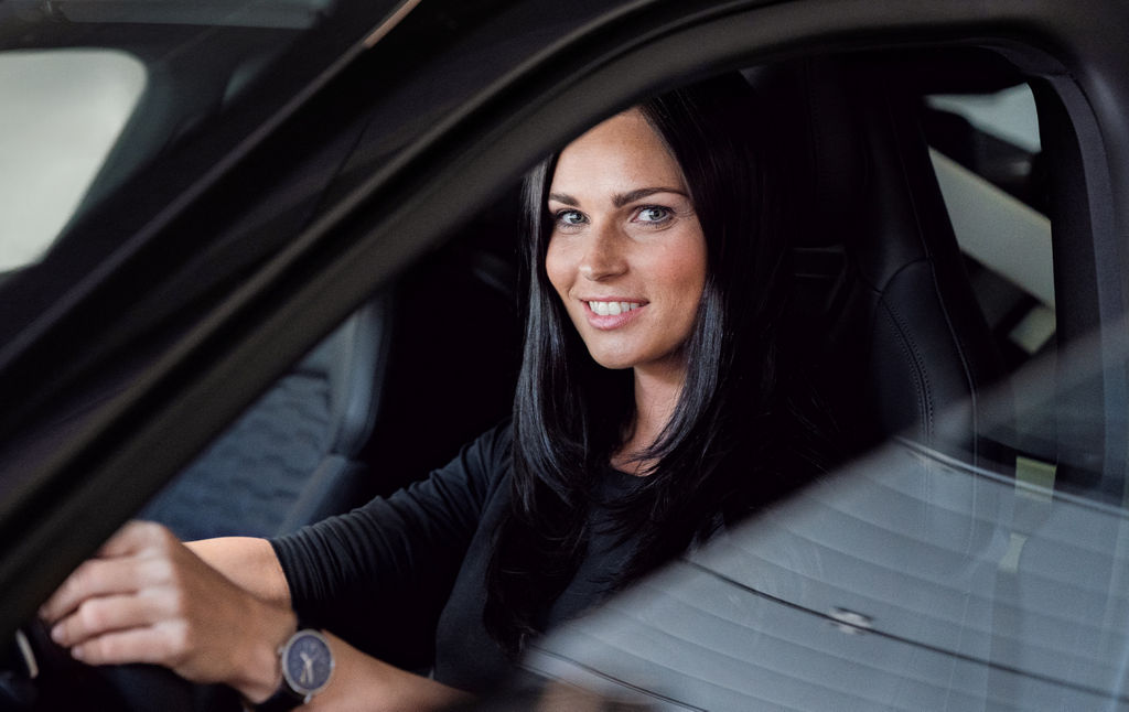Anna Veith está sentada al volante del Audi e-tron GT y mira a la cámara.