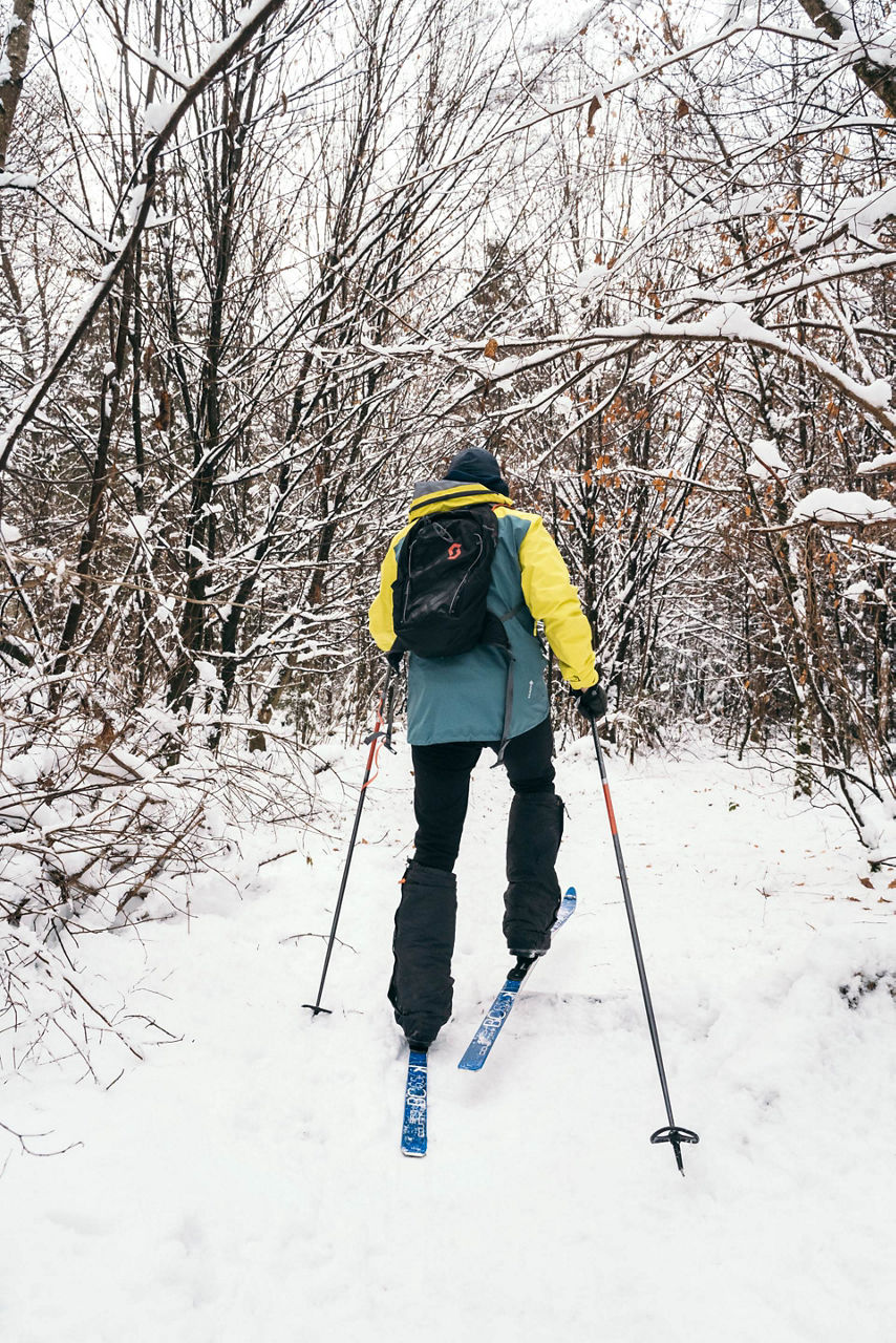 Sebastian Copeland skiing through the woods.