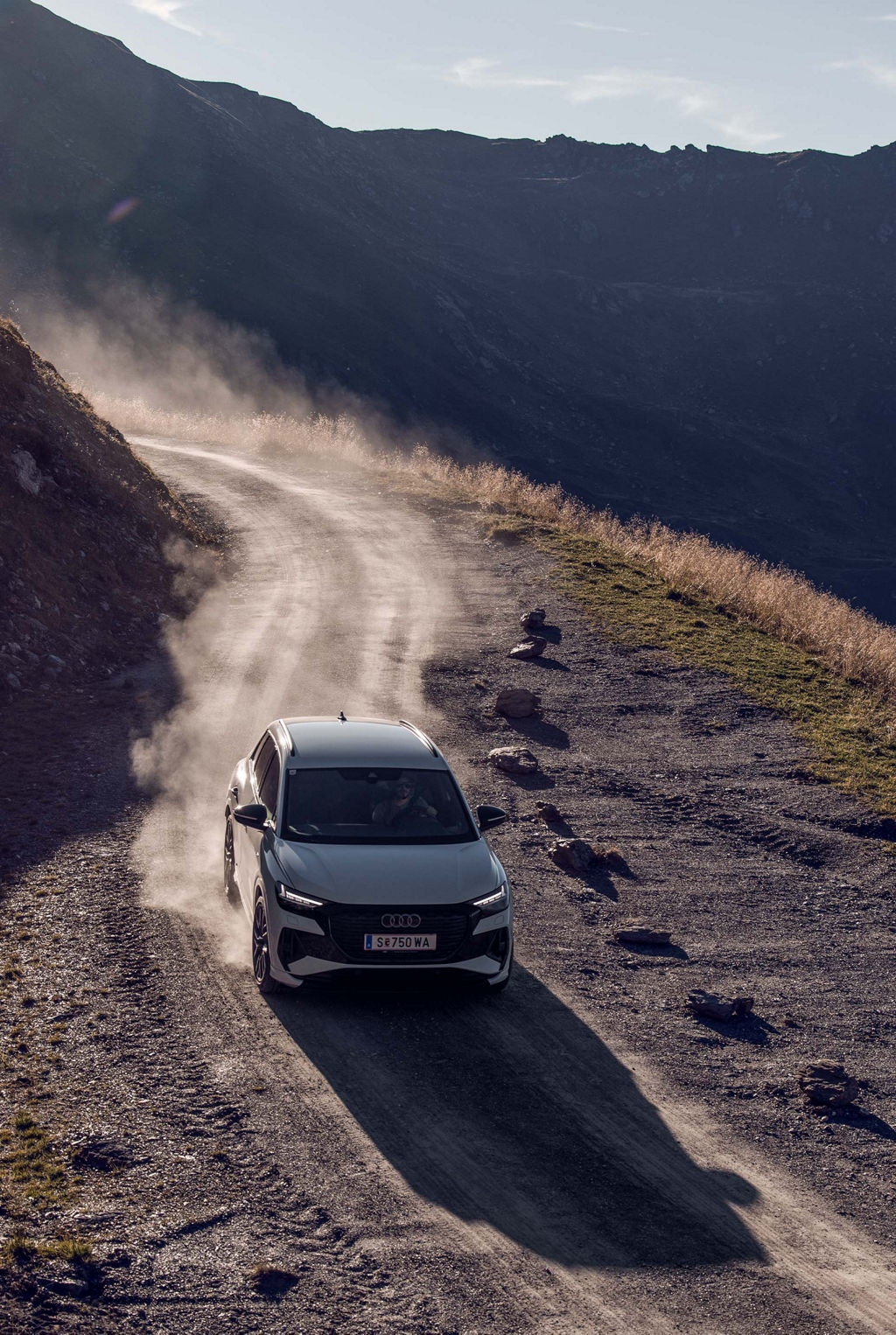 En vit Audi Q4 e-tron kör på en bergsväg.