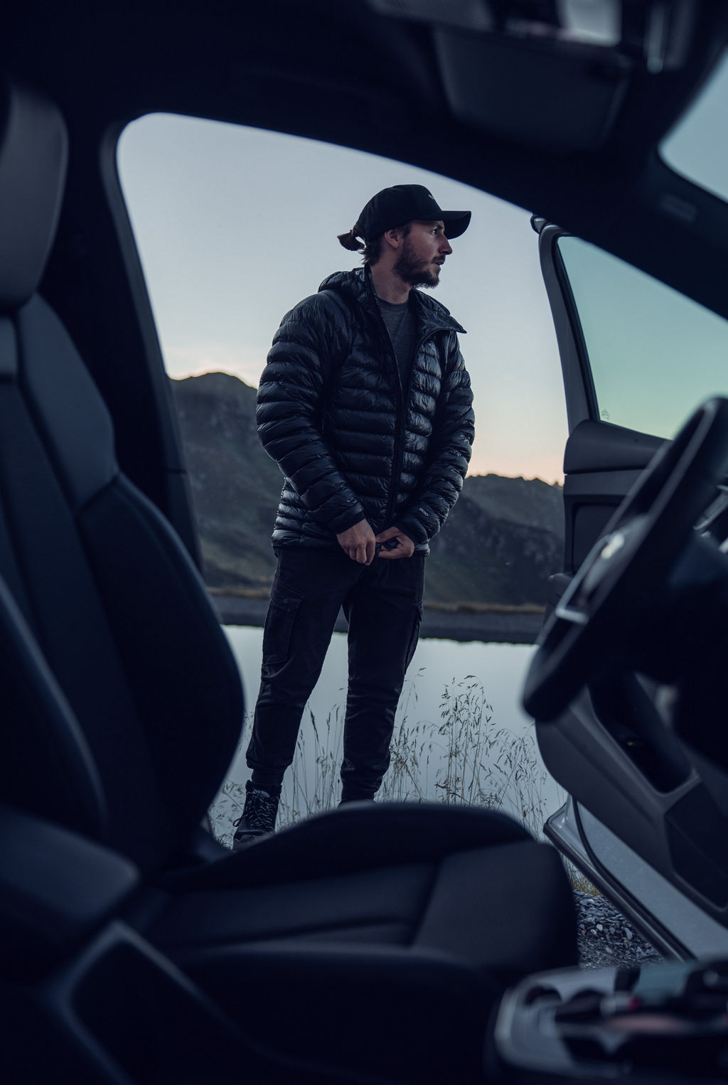 Tom Klocker står framför en öppen bildörr och tittar ut i fjärran.