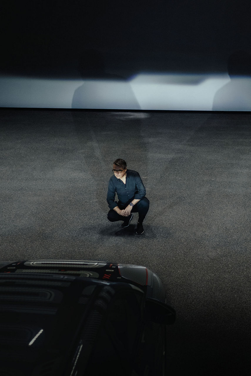 César Muntada crouches down and looks into the Audi Q4 e-tron’s headlights.
