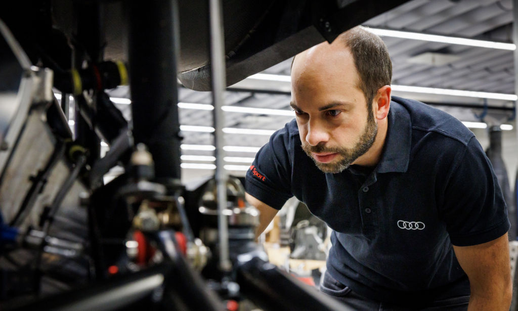 Benedikt Brunninger inspiziert ein Detail am demontierten Audi RS Q e-tron.