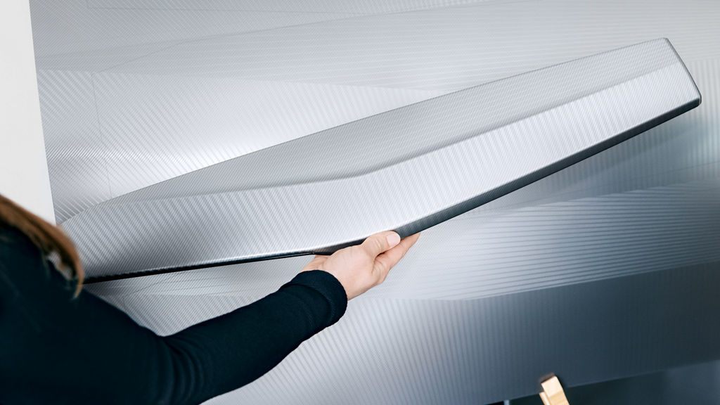 The Color & Trim team holds color and material samples on car body parts