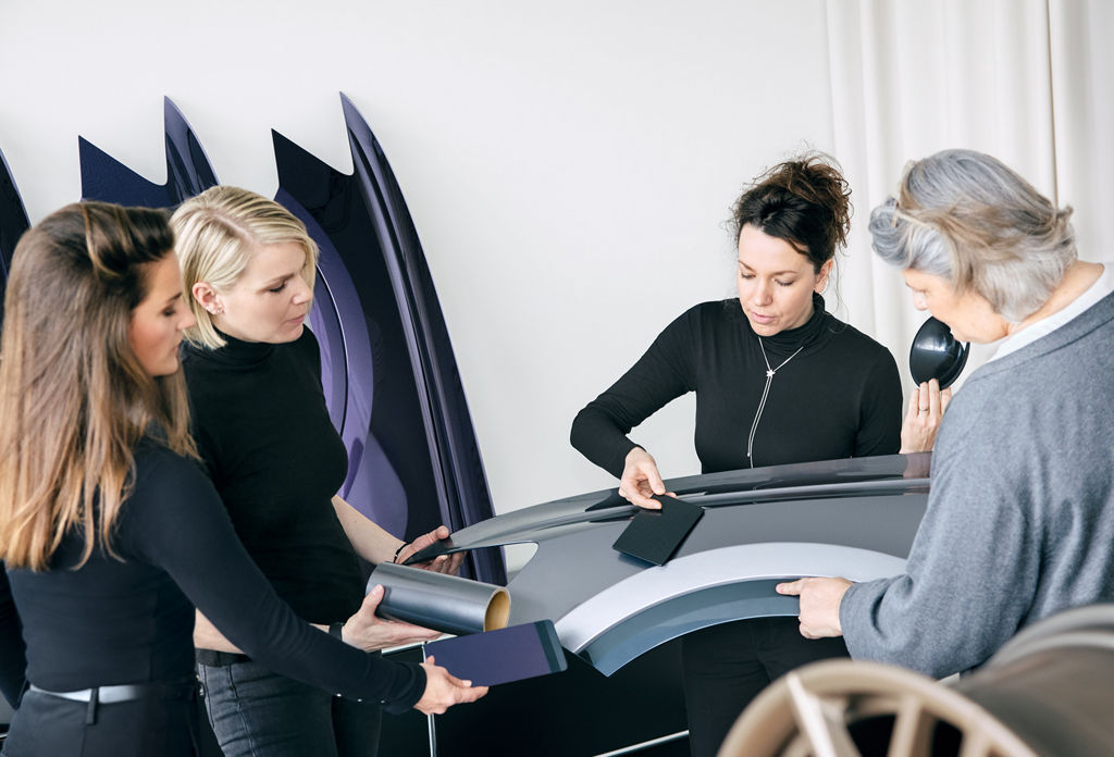 The Colour & Trim team holds colour and material samples on car body parts