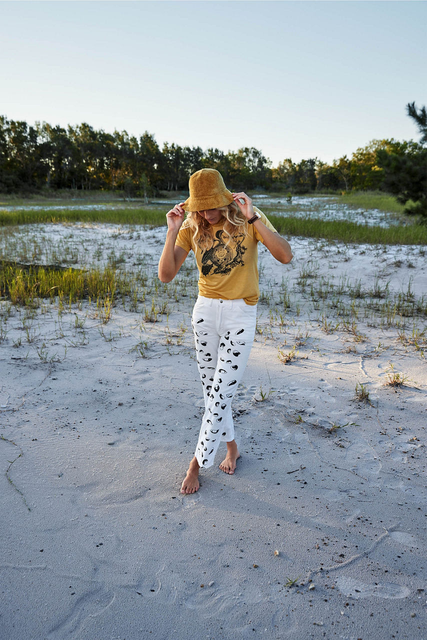 Steph Gilmore outside, in long shot, wearing a sun hat