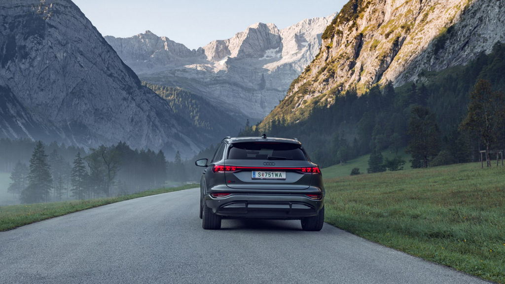 Heckansicht des Audi Q6 e-tron in einer Berglandschaft.