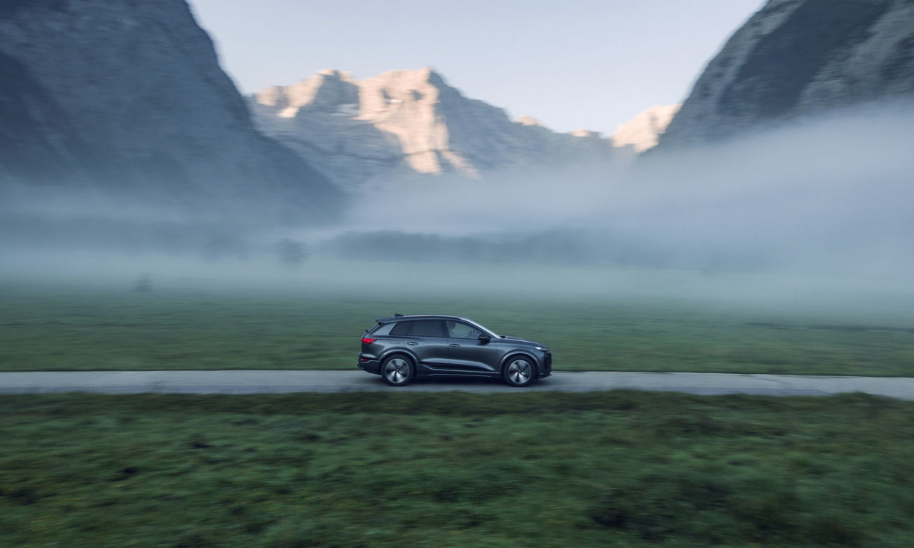 Audi Q6 e-tron kjører gjennom et fjellandskap.
