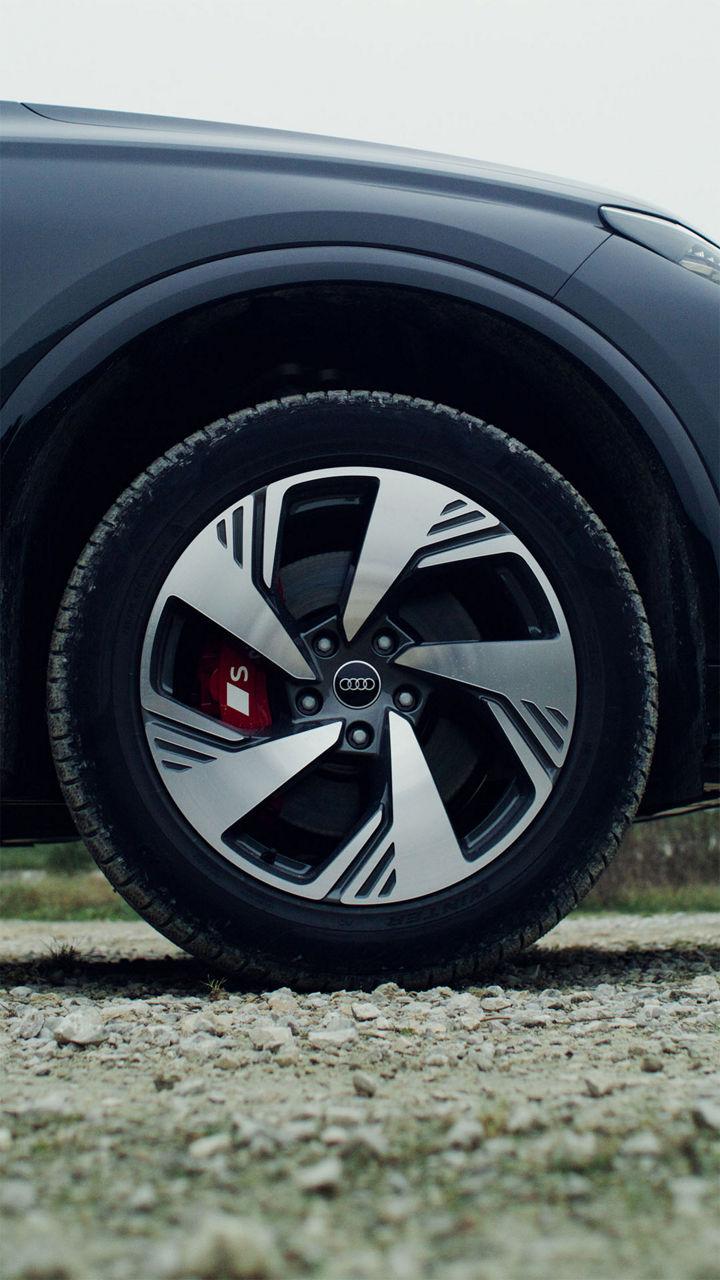 Nærbilde av et forhjul på Audi SQ6 e-tron. S-logoen kan sees på en rød bremsekaliper.