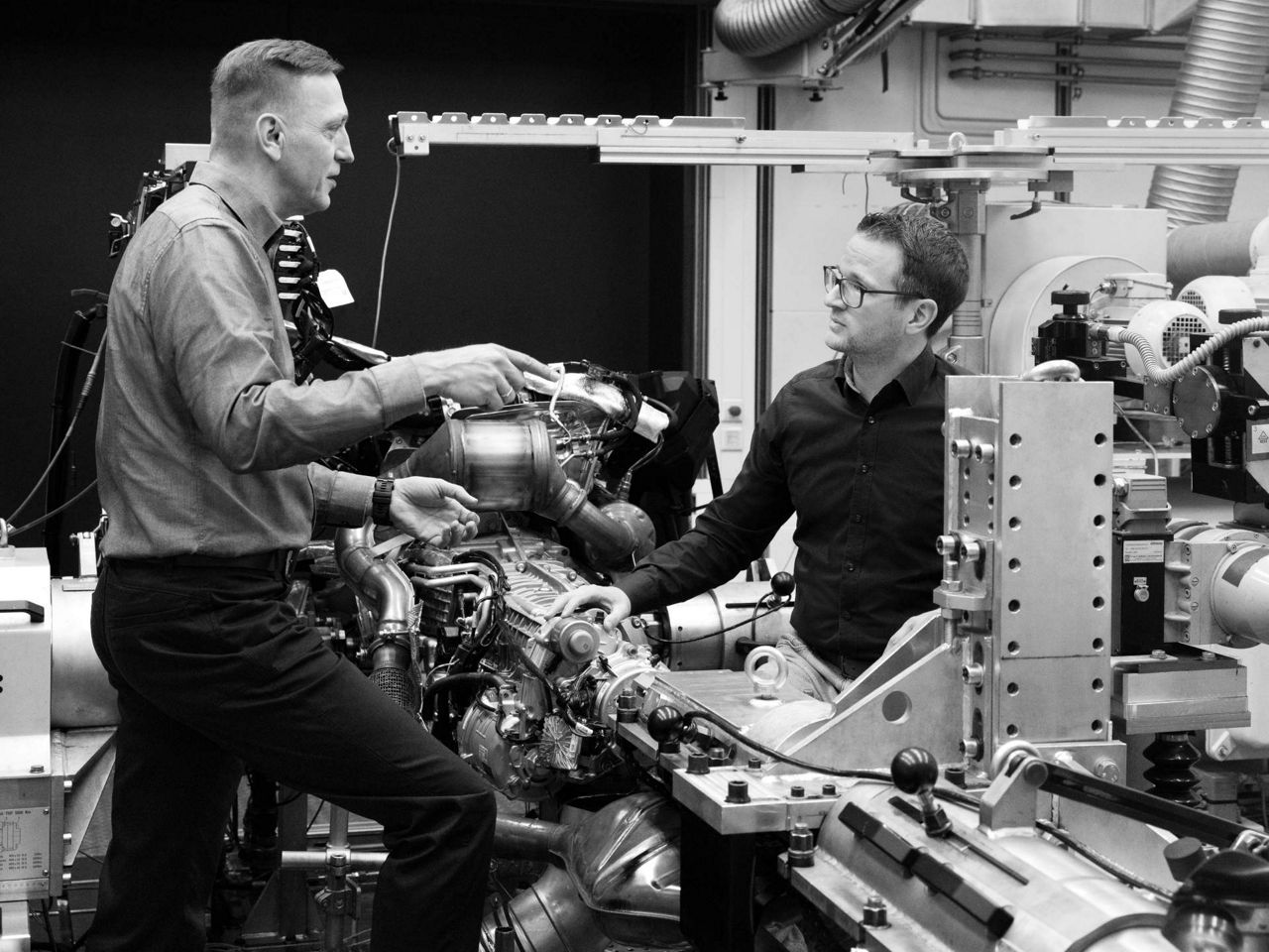 Dieter Weidemann og Bastian Heidler diskuterer et drivverk. Detaljer om en forbrenningsmotor og girkassen kan sees.