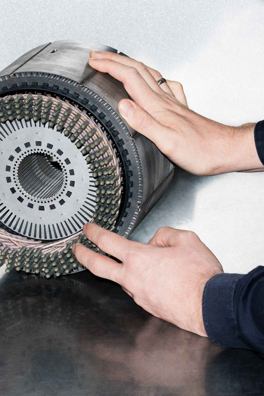 Bastian Heidlers hender peker ut detaljer på en elektrisk motor som brukes i nåværende helelektriske Audi-modeller.