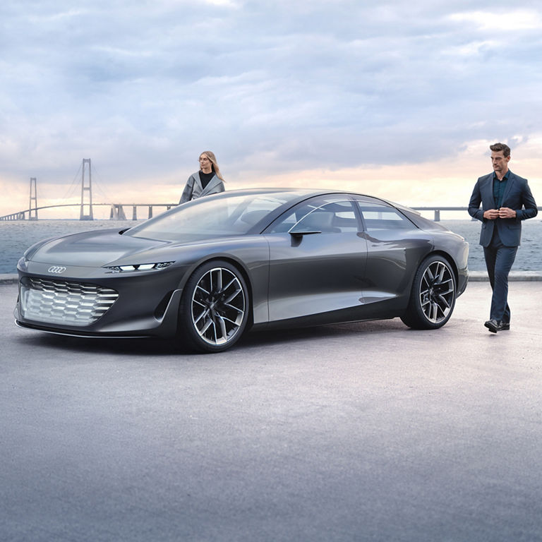 Front view of the Audi grandsphere concept in front of a bridge. 