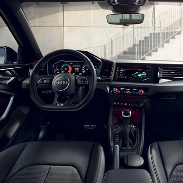 Innenraum des Audi A1 Sportback mit Lenkrad, digitalem Cockpit und Touchscreen in der Mittelkonsole.