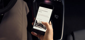 Man holding a smartphone with the myAudi app open