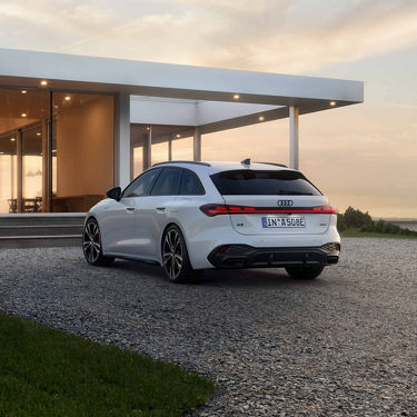 Audi A5 Avant e-hybrid rear view in front of a house