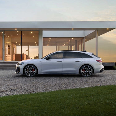 Audi A5 Avant e-hybrid side view of a house
