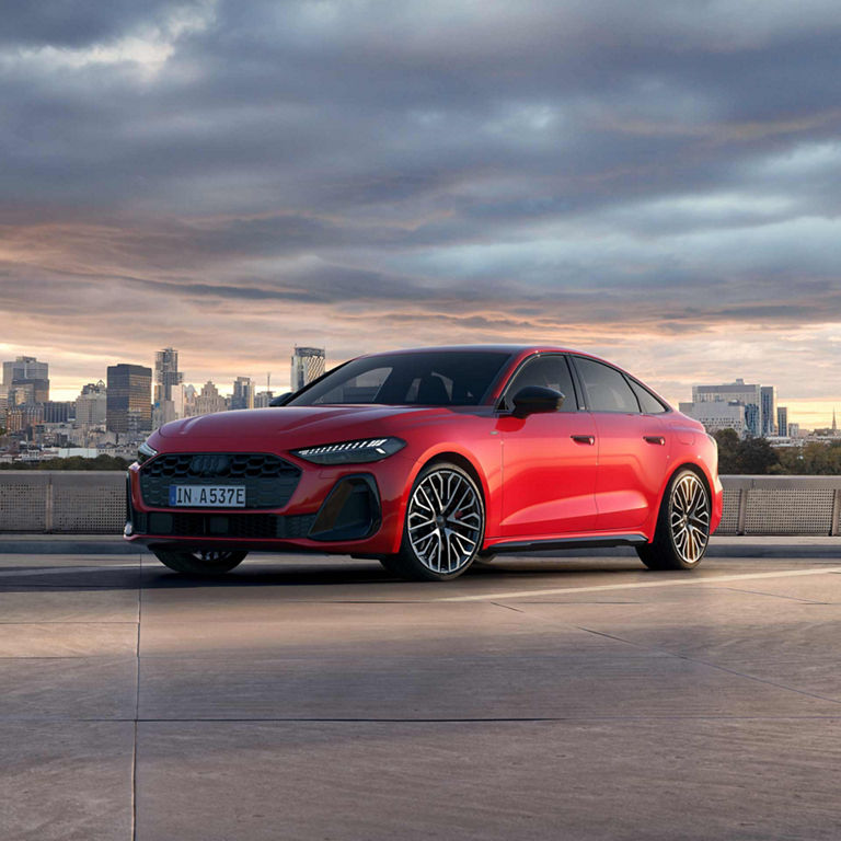 Audi A5 saloon e-hybrid in red in a parking lot
