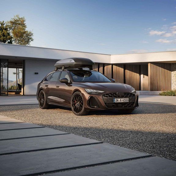 Audi A6 Avant side view with the roof box and family