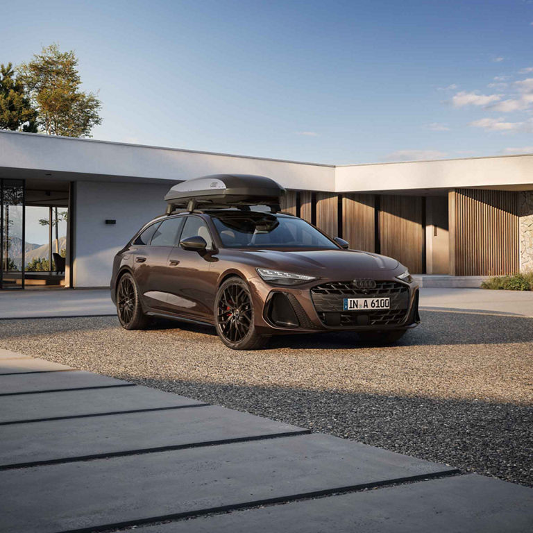 Audi A6 Avant side view with the roof box and family