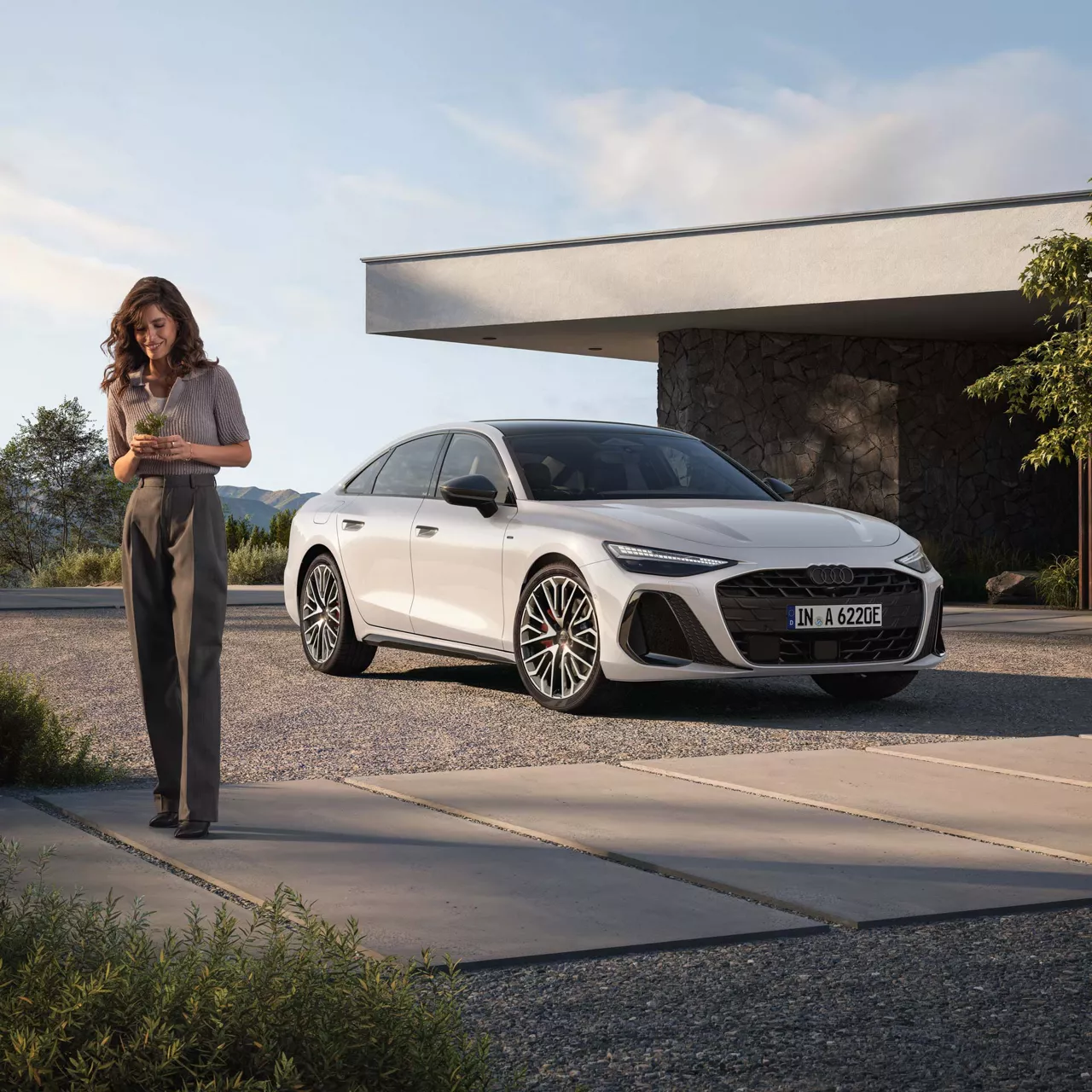 Audi A6 Limousine e-hybrid Auf einem Parkplatz mit Model daneben