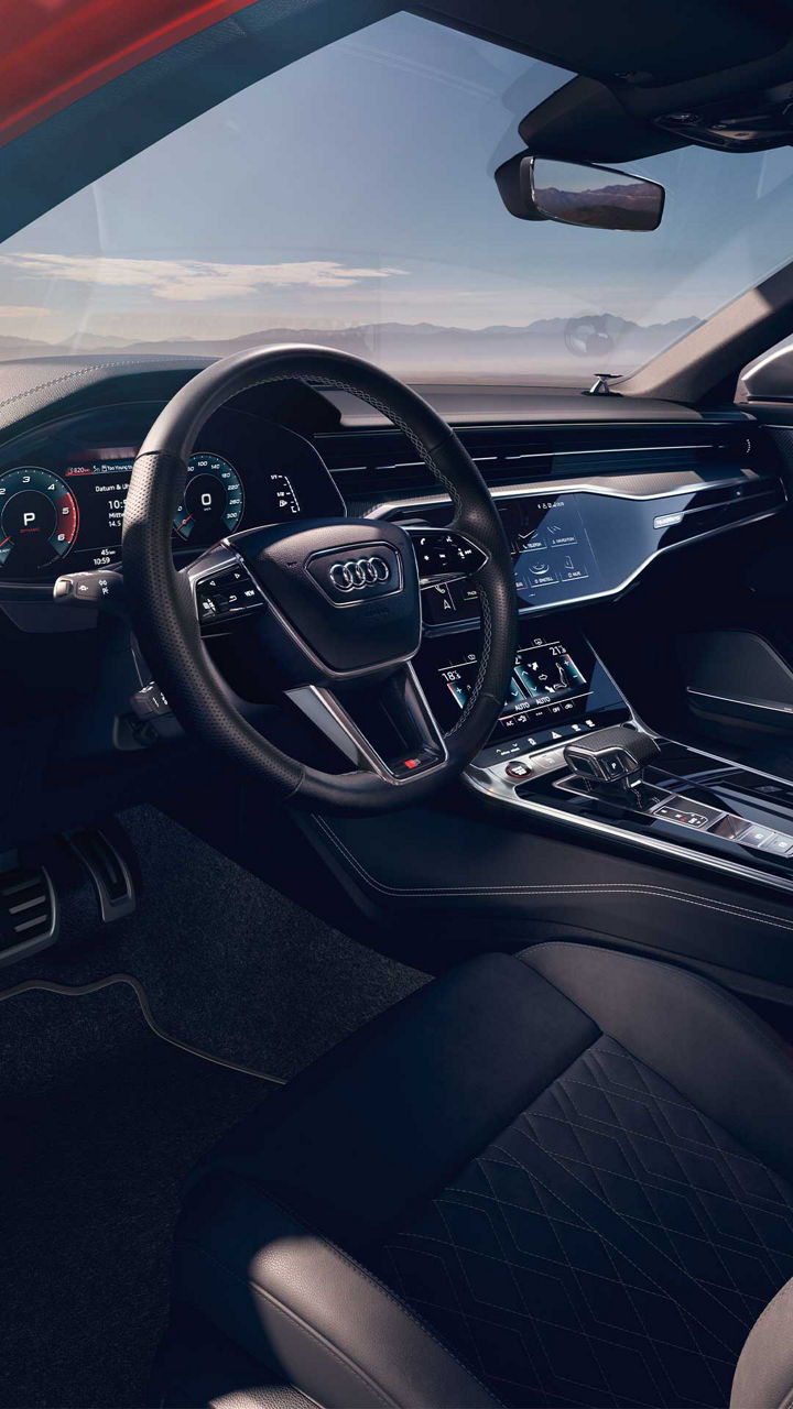 Blick auf das hochwertige schwarze Cockpit mit digitalem Display und Ledersitzen im Audi S6 Avant TDI.