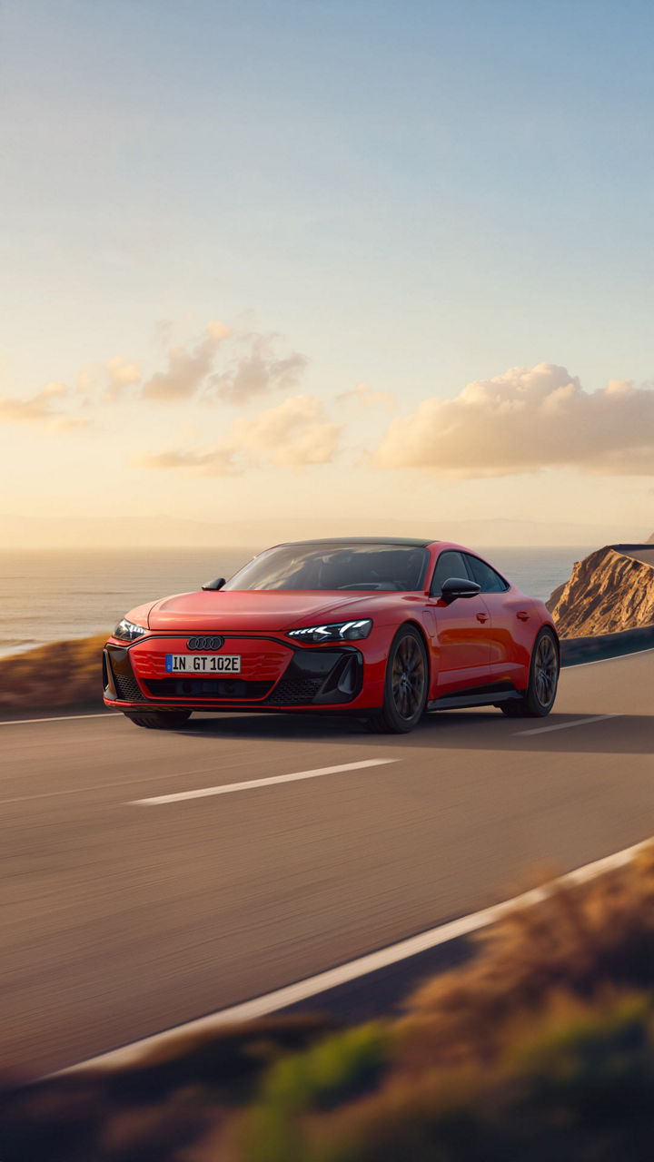 Audi e-tron GT quattro dynamic side view on a road at sunset