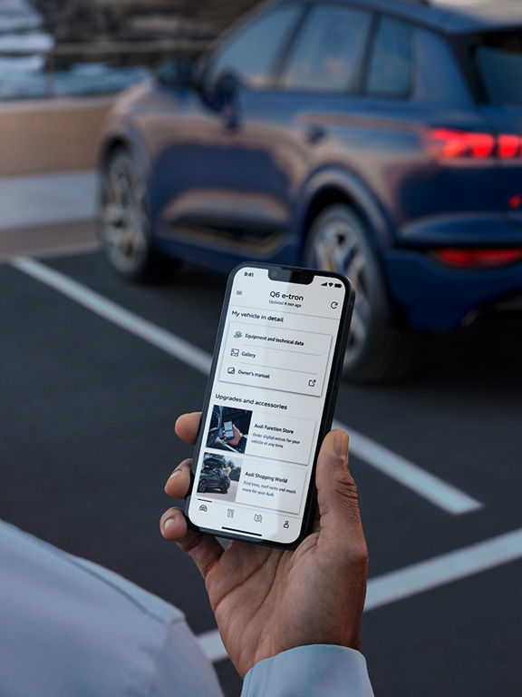 Man holding smartphone with the myAudi app