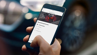 Man holding a smartphone with the myAudi app open