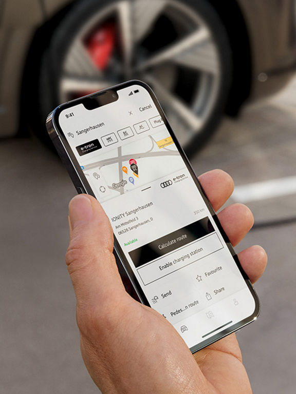 Man with smartphone in front of Audi Q8 e-tron