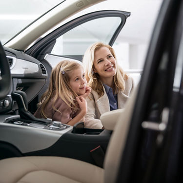 Frau und Kind gucken in ein Fahrzeug