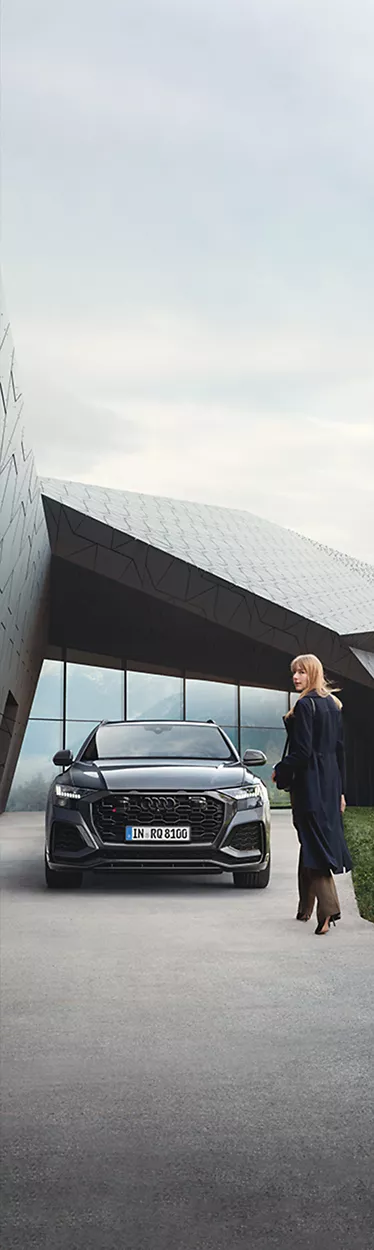 Frau läuft auf Audi RS Q8 zu