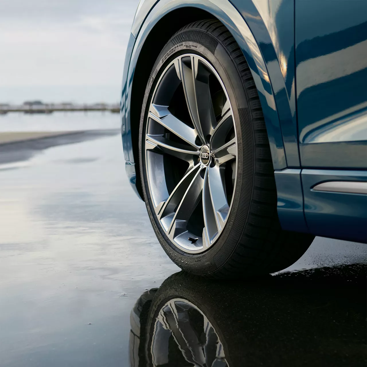 A closeup of a silver alloy wheel on an Audi.