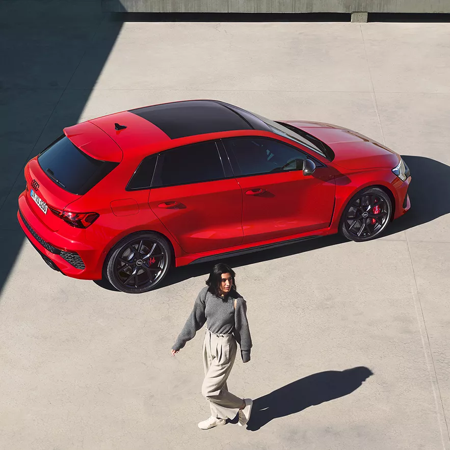 Audi RS 3 Sportback sideways from above and a young woman