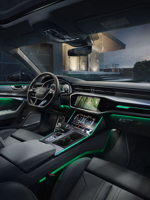 Close-up auf das vordere Interieur des Audi A6 mit Ambientebeleuchtung im Thema 'Costa Rica' in Grün.