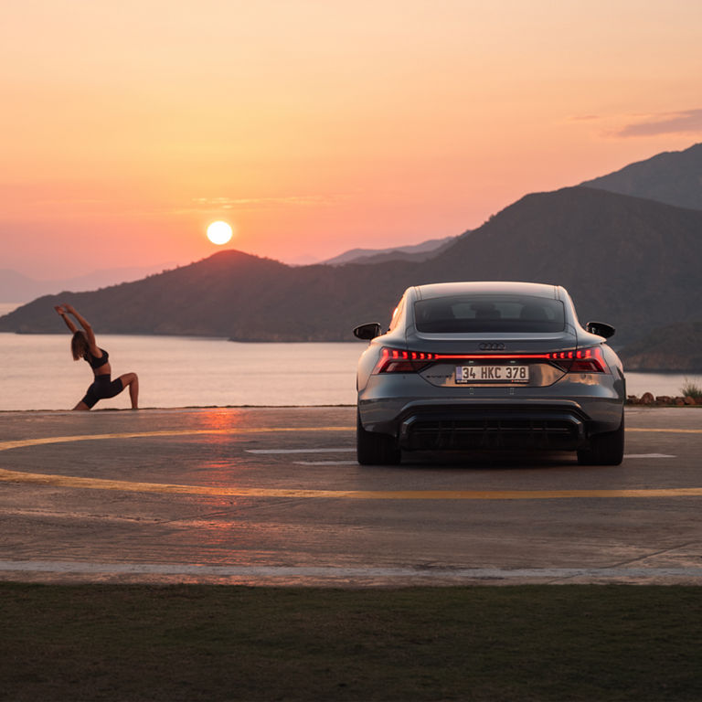 Audi RS e-tron GT sports car on a concrete surface in front of futuristic architecture