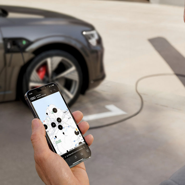 Man with smartphone in front of Audi Q8 e-tron